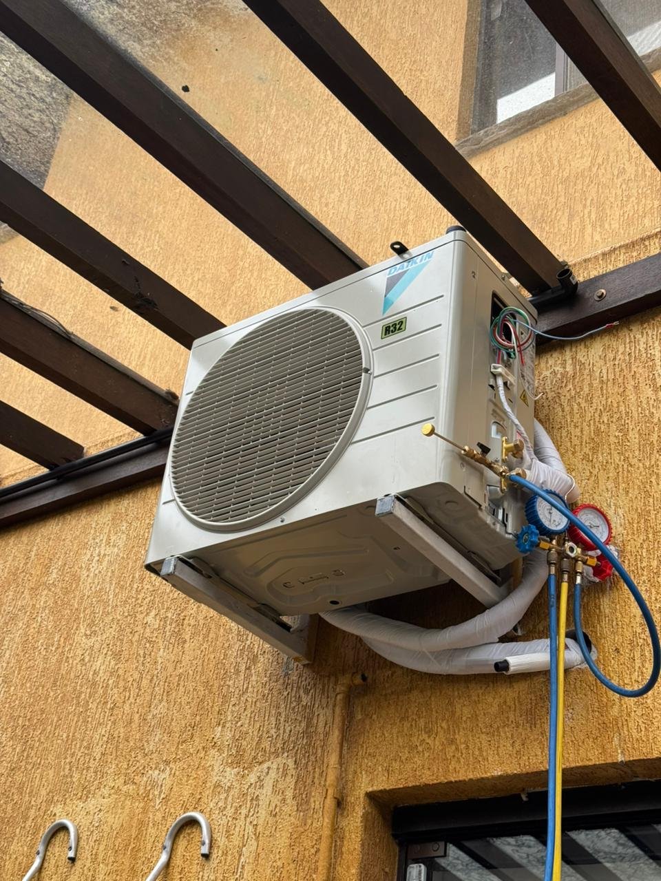 Técnico verificando pressão do gás na manutenção de ar condicionado